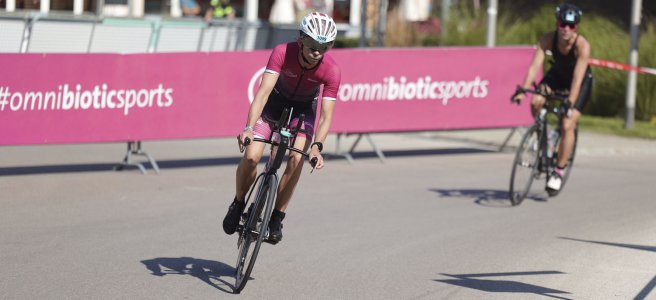 Nadja Hauser im OmniBiotic-Dress auf dem Rennrad während eines Triathlon. Unterstützt durch das Nahrungsergänzungsmittel Omni-Biotic.